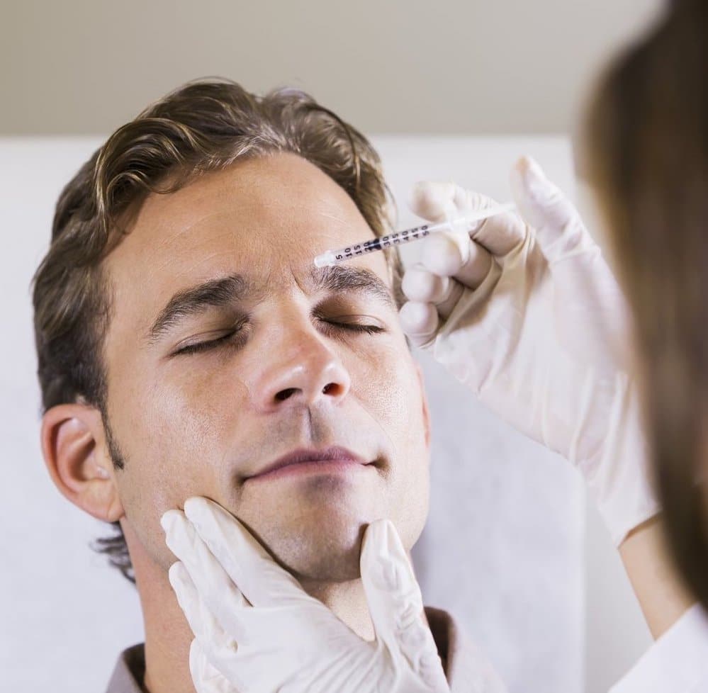 Mid adult man (30s) receiving botulinum toxin injection.